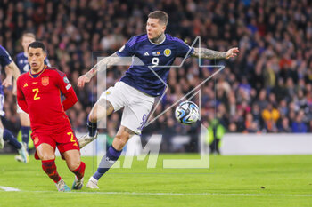 2023-03-28 - Lyndon Dykes of Scotland and Pedro Porro of Spain during the UEFA Euro 2024, European Qualifiers, Group A football match between Scotland and Spain on March 28, 2023 at Hampden Park in Glasgow, Scotland - FOOTBALL - EURO 2024 - QUALIFYING - SCOTLAND V SPAIN - UEFA EUROPEAN - SOCCER