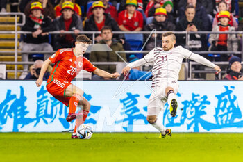 2023-03-28 - Wales' forward Daniel James (20) under pressure from Latvian defender Roberts Savaļnieks (11) during the UEFA Euro 2024, European Qualifiers football match between Wales and Latvia on 28 March 2023 at the Cardiff City Stadium in Cardiff, Wales - FOOTBALL - EURO 2024 - QUALIFYING - WALES V LATVIA - UEFA EUROPEAN - SOCCER