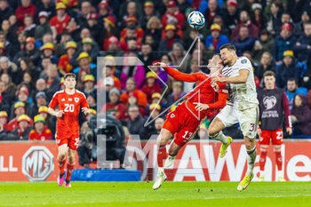 2023-03-28 - Wales' forward Kiefer Moore (13) competes for a ball with Latvian defender Marcis Oss (3) during the UEFA Euro 2024, European Qualifiers football match between Wales and Latvia on 28 March 2023 at the Cardiff City Stadium in Cardiff, Wales - FOOTBALL - EURO 2024 - QUALIFYING - WALES V LATVIA - UEFA EUROPEAN - SOCCER