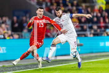 2023-03-28 - Wales' forward Kiefer Moore (13) under pressure from Latvian defender Antonio’s Cernomordijs during the UEFA Euro 2024, European Qualifiers football match between Wales and Latvia on 28 March 2023 at the Cardiff City Stadium in Cardiff, Wales - FOOTBALL - EURO 2024 - QUALIFYING - WALES V LATVIA - UEFA EUROPEAN - SOCCER