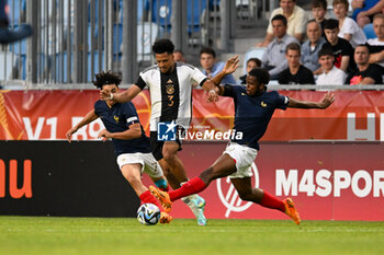 2023-06-02 - Germany U17’s Almugera Kabar pass in the middle of France U17’s Mohammed-Amine Boucehnna and France U17’s Joachim Kayi Sanda during the final phase Under-17 Championship Hungary 2023 soccer match Germany U17 vs. France U17 at the Nandor Hidegkuti Stadion stadium in Budapest, Hungary, 2nd of June 2023 - UNDER 17 FINAL - GERMANY VS FRANCE - UEFA EUROPEAN - SOCCER