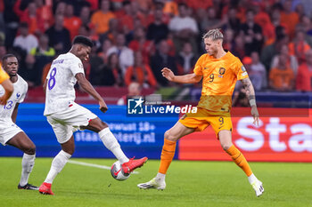 2023-10-13 - Aurelien Tchouameni of France battles for the ball with Wout Weghorst of the Netherlands during the UEFA Euro 2024, Qualifiers Group B football match between Netherlands and France on October 13, 2023 at Johan Cruijff ArenA in Amsterdam, Netherlands - FOOTBALL - EURO 2024 - QUALIFYING - NETHERLANDS V FRANCE - UEFA EUROPEAN - SOCCER