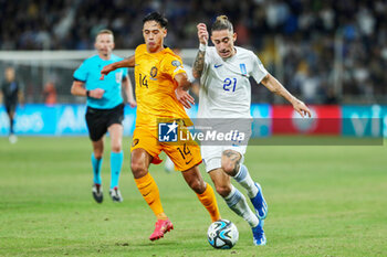 2023-10-16 - Tijjani Reijnders of the Netherlands battles for possession with Kostas Tsimikas of Greece during the UEFA Euro 2024, Qualifiers Group B football match between Greece and Netherlands on October 16, 2023 at OPAP Arena in Athens, Greece - FOOTBALL - EURO 2024 - QUALIFYING - GREECE V NETHERLANDS - UEFA EUROPEAN - SOCCER