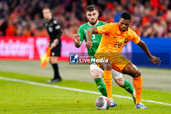 2023-11-18 - Ryan Manning of Ireland battles for possession with Denzel Dumfries of The Netherlands during the UEFA EURO 2024, Qualifiers Group B football match between Netherlands and Republic of Ireland on November 18, 2023 at Johan Cruijff ArenA in Amsterdam, Netherlands - FOOTBALL - EURO 2024 - QUALIFYING - NETHERLANDS V REPUBLIC OF IRELAND - UEFA EUROPEAN - SOCCER