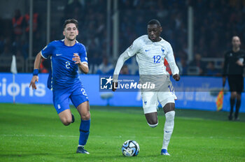 2023-11-21 - 12 Randal Kolo Muani of France competing with 2 Panagiotis Retsos of Greece during the European Qualifiers for Euro 24, Group B, match between Greece and France at OPAP Arena on November 21, 2023, in Athens, Greece. - GREECE VS FRANCE, EUROPEAN QUALIFIERS, EURO 2024 - UEFA EUROPEAN - SOCCER