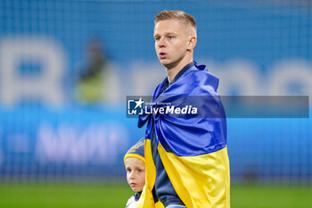 2023-11-20 - Oleksandr Zinchenko walking onto the pitch holding the flag of Ukraine during the UEFA Euro 2024, Qualifiers Group C football match between Ukraine and Italy on November 20, 2023 at BayArena in Leverkusen, Germany - FOOTBALL - EURO 2024 - QUALIFYING - UKRAINE V ITALY - UEFA EUROPEAN - SOCCER