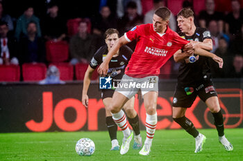2023-08-08 - Joey Veerman of PSV battles for possession with Alexander Prass of Sturm Graz during the UEFA Champions League, Third qualifying round, 1st leg football match between PSV and SK Sturm Graz on August 8, 2023 at Philips Stadion in Eindhoven, Netherlands - FOOTBALL - CHAMPIONS LEAGUE - PSV V STURM GRAZ - UEFA CHAMPIONS LEAGUE - SOCCER