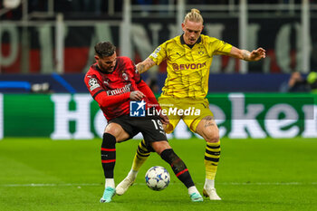 2023-11-28 - Theo Hernandez of AC Milan competes for the ball with Marius Wolf of Borussia Dortmund during UEFA Champions League 2023/24 Group Stage - Group F football match between AC Milan and Borussia Dortmund at San Siro Stadium, Milan, Italy on November 28, 2023 - AC MILAN VS BORUSSIA DORTMUND - UEFA CHAMPIONS LEAGUE - SOCCER