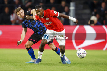 2023-10-03 - Johan Bakayoko of PSV battles for possession with Adria Pedrosa of Sevilla FC during the UEFA Champions League, Group B football match between PSV Eindhoven and Sevilla FC on October 3, 2023 at the Phillips Stadion in Eindhoven, Netherlands - FOOTBALL - CHAMPIONS LEAGUE - PSV EINDHOVEN V SEVILLA - UEFA CHAMPIONS LEAGUE - SOCCER