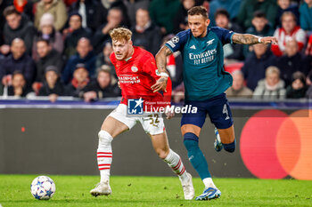2023-12-12 - Yorbe Vertessen of PSV is challenged by Ben White of Arsenal during the UEFA Champions League, Group B football match between PSV and Arsenal on December 12, 2023 at the Phillips Stadion in Eindhoven, Netherlands - FOOTBALL - CHAMPIONS LEAGUE - PSV V ARSENAL - UEFA CHAMPIONS LEAGUE - SOCCER