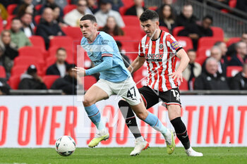 2023-04-24 - Phil Foden (47) of Manchester City battles for possession with John Egan (12) of Sheffield United during the English Cup, FA Cup semi final football match between Manchester City and Sheffield United on 22 April 2023 at Wembley Stadium in London, England - FOOTBALL - ENGLISH CUP - MANCHESTER CITY V SHEFFIELD UNITED - ENGLISH LEAGUE CUP - SOCCER