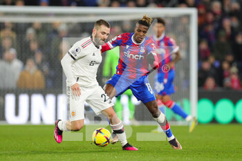 2023-01-19 - Manchester United defender Luke Shaw (23) and Crystal Palace (11) Wilfried Zaha during the English championship Premier League football match between Crystal Palace and Manchester United on January 18, 2023 at Selhurst Park in London, England - FOOTBALL - ENGLISH CHAMP - CRYSTAL PALACE V MANCHESTER UNITED - ENGLISH PREMIER LEAGUE - SOCCER