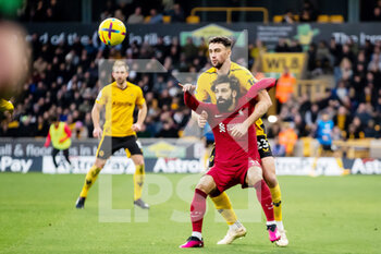 2023-02-04 - Liverpool forward Mohamed Salah (11) battles for possession with Wolverhampton Wanderers defender Max Kilman during the English championship Premier League football match between Wolverhampton Wanderers and Liverpool on February 4, 2023 at Molineux stadium in Wolverhampton, England - FOOTBALL - ENGLISH CHAMP - WOLVERHAMPTON V LIVERPOOL - ENGLISH PREMIER LEAGUE - SOCCER