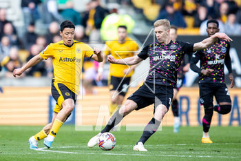 2023-04-15 - Wolverhampton Wanderers forward Hwang Hee-Chan (11) battles for possession with Brentford defender Ben Mee (16) during the English championship Premier League football match between Wolverhampton Wanderers and Brentford on 15 April 2023 at Molineux stadium in Wolverhampton, England - FOOTBALL - ENGLISH CHAMP - WOLVERHAMPTON V BRENTFORD - ENGLISH PREMIER LEAGUE - SOCCER