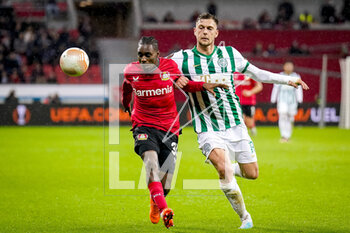 2023-03-09 - Jeremie Frimpong of Bayer 04 Leverkusen is challenged by Balint Vecsei of Ferencvaros during the UEFA Europa League, Round of 16, 1st leg football match between Bayer 04 Leverkusen and Ferencvaros TC on March 9, 2023 at the BayArena in Leverkusen, Germany - FOOTBALL - EUROPA LEAGUE - LEVERKUSEN V FERENCVAROS - UEFA EUROPA LEAGUE - SOCCER