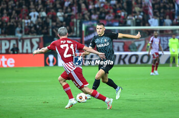 2023-09-21 - 8 Maximilian Eggestein of SC Freiburg competing with 21 Pep Biel of Olympiacos FC during the Europa League Group A match between Olympiacos FC and SC Freiburg at Georgios Karaiskakis Stadium on September 21, 2023, in Athens, Greece. - OLYMPIACOS VS FREIBURG, EUROPA LEAGUE, GROUP A - UEFA EUROPA LEAGUE - SOCCER