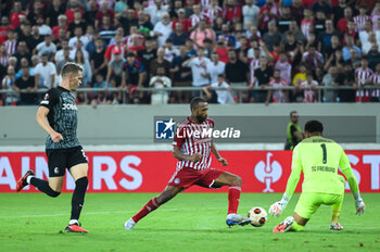 2023-09-21 - 9 Ayoub El Kaabi of Olympiacos FC competing with 1 Noah Atubolu of SC Freiburg during the Europa League Group A match between Olympiacos FC and SC Freiburg at Georgios Karaiskakis Stadium on September 21, 2023, in Athens, Greece. - OLYMPIACOS VS FREIBURG, EUROPA LEAGUE, GROUP A - UEFA EUROPA LEAGUE - SOCCER
