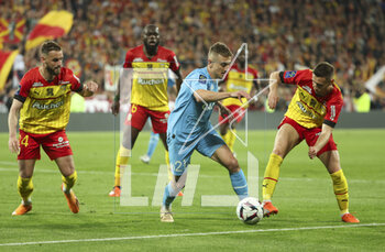 2023-05-06 - Valentin Rongier of Marseille between Jonathan Gradit and Przemyslaw Frankowski of Lens during the French championship Ligue 1 football match between RC Lens (RCL) and Olympique de Marseille (OM) on May 6, 2023 at Stade Bollaert-Delelis in Lens, France - FOOTBALL - FRENCH CHAMP - LENS V MARSEILLE - FRENCH LIGUE 1 - SOCCER