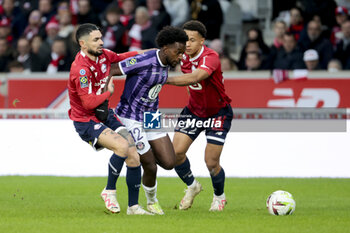 2023-11-12 - Warren Kamanzi of Toulouse between Remy Cabella and Tiago Santos of Lille during the French championship Ligue 1 football match between Losc Lille and Toulouse Herault SC on November 12, 2023 at Decathlon Arena Stade Pierre Mauroy in Villeneuve-d'Ascq near Lille, France - FOOTBALL - FRENCH CHAMP - LILLE V TOULOUSE - FRENCH LIGUE 1 - SOCCER