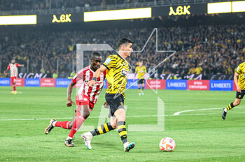 2023-05-03 - 20 PETROS MANTALOS of AEK FC competing with 38 DIADIE SAMASSEKOU of Olympiacos FC during the Greek Super League, playoff match between AEK FC and Olympiacos FC at OPAP Arena on May 3, 2023, in Athens, Greece. - AEK VS OLYMPIACOS - GREEK SUPER LEAGUE - SOCCER