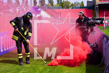 2023-04-23 - A firefighter picks up a smoke bomb thrown by fans at the edge of the pitch - AC MONZA VS ACF FIORENTINA - ITALIAN SERIE A - SOCCER