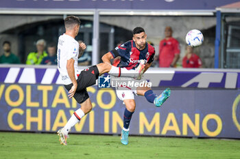 2023-08-21 - Bologna's Charalampos Lykogiannis hindered by Milan's Christian Pulisic - BOLOGNA FC VS AC MILAN - ITALIAN SERIE A - SOCCER