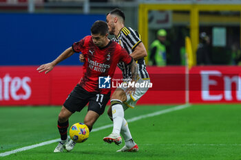 2023-10-22 - Christian Pulisic of AC Milan (L) competes for the ball with Federico Gatti of Juventus FC (R) during Serie A 2023/24 football match between AC Milan and Juventus FC at San Siro Stadium, Milan, Italy on October 22, 2023 - AC MILAN VS JUVENTUS FC - ITALIAN SERIE A - SOCCER