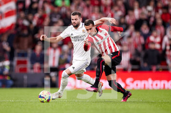 2023-01-22 - Alex Berenguer of Athletic Club competes for the ball with Nacho Fernandez of Real Madrid during the Spanish championship La Liga football match between Athletic Club and Real Madrid CF on January 22, 2023 at San Mames stadium in Bilbao, Spain - FOOTBALL - SPANISH CHAMP - ATHLETIC CLUB V REAL MADRID - SPANISH LA LIGA - SOCCER