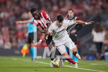 2023-04-27 - Marcos Javier Acuna of Sevilla FC competes for the ball with Inaki Williams of Athletic Club during the Spanish championship La Liga football match between Athletic Club and Sevilla FC on April 27, 2023 at San Mames stadium in Bilbao, Spain - FOOTBALL - SPANISH CHAMP - ATHLETIC CLUB V SEVILLA FC - SPANISH LA LIGA - SOCCER