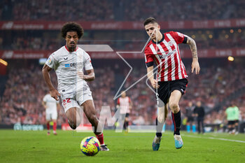 2023-04-27 - Loic Bade of Sevilla FC competes for the ball with Oihan Sancet of Athletic Club during the Spanish championship La Liga football match between Athletic Club and Sevilla FC on April 27, 2023 at San Mames stadium in Bilbao, Spain - FOOTBALL - SPANISH CHAMP - ATHLETIC CLUB V SEVILLA FC - SPANISH LA LIGA - SOCCER