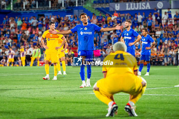 2023-08-13 - Gaston Alvarez (Getafe) protesting with Ronald Araujo (Barcelona) after the controversial play with the alleged penalty not whistled by the referee at the end of the LaLiga EA Sports football match between Getafe and Barcelona played at Coliseum Alfonso Perez Stadium on August 13, 2023 in Getafe, Spain - GETAFE VS BARCELONA - SPANISH LA LIGA - SOCCER