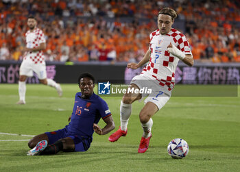2023-06-14 - Lovro Majer of Croatia, left Tyrell Malacia of Netherlands during the UEFA Nations League, Semi-finals football match between Netherlands and Croatia on June 14, 2023 at Stadion Feijenoord 'De Kuip' in Rotterdam, Netherlands - FOOTBALL - UEFA NATIONS LEAGUE 2023 - 1/2 - NETHERLANDS V CROATIA - UEFA NATIONS LEAGUE - SOCCER