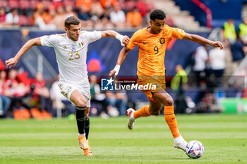2023-06-18 - Alessandro Buongiorno of Italy battles for the ball with Cody Gakpo of The Netherlands during the UEFA Nations League 2023, Third-place match between Netherlands and Italy on June 18, 2023 at De Grolsch Veste, FC Twente stadium in Enschede, Netherlands - FOOTBALL - UEFA NATIONS LEAGUE 2023 - 3RD PLACE - NETHERLANDS V ITALY - UEFA NATIONS LEAGUE - SOCCER