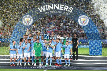 2023-08-16 - The Manchester City players celebrate with the trophy after their victory in a penalty shootout during the UEFA Super Cup 2023 match between Manchester City FC and Sevilla FC at Karaiskakis Stadium on August 16, 2023 in Piraeus, Greece. - UEFA SUPER CUP MANCHESTER CITY VS SEVILLA FC - UEFA SUPER CUP - SOCCER