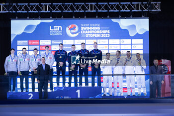 2023-12-05 - Team of Great Britain, Team of Italy and Team of Greece during the prize giving ceremony for Men´s 4x50m Freestyle at the LEN Short Course European Championships 2023 on December 5, 2023 in Otopeni, Romania - SWIMMING - LEN SHORT COURSE EUROPEAN CHAMPIONSHIPS 2023 - SWIMMING - SWIMMING