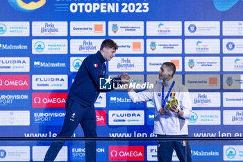 2023-12-10 - Grousset Maxime of France and David Popovici of Romania shaking hands during the podium ceremony for Men’s 100m Freestyle at the LEN Short Course European Championships 2023 on December 10, 2023 in Otopeni, Romania - SWIMMING - LEN SHORT COURSE EUROPEAN CHAMPIONSHIPS 2023 - DAY 6 - SWIMMING - SWIMMING