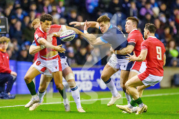 2023-02-11 - Rio Dyer of Wales offloads the ball as he is tackled during the Six Nations 2023, rugby union match between Scotland and Wales on February 11, 2023 at BT Murrayfield Stadium in Edinburgh, Scotland - RUGBY - SIX NATIONS 2023 - SCOTLAND V WALES - SIX NATIONS - RUGBY