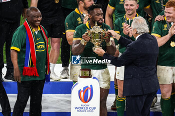 2023-10-28 - Siya KOLISI of South Africa receives the trophy from World Rugby President Bill BEAUMONT under the President of South Africa Cyril RAMAPHOSA eyes during the World Cup 2023, Final rugby union match between New Zealand and South Africa on October 28, 2023 at Stade de France in Saint-Denis near Paris, France - RUGBY - WORLD CUP 2023 - FINAL - NEW ZEALAND V SOUTH AFRICA - WORLD CUP - RUGBY