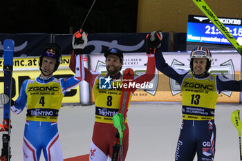 2023-12-22 - (L to R) Clement Noel (FRA) second place, Marco Schwarz (AUT) first place and Dave Ryding (GBR) third place at the Audi FIS Alpine Ski World Cup, Men’s Slalom race on 3Tre Slope in Madonna di Campiglio on December 22, 2023, Trento, Italy. - AUDI FIS SKI WORLD CUP - MEN'S SLALOM - ALPINE SKIING - WINTER SPORTS