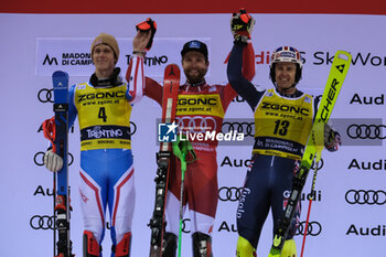 2023-12-22 - (L to R) Clement Noel (FRA) second place, Marco Schwarz (AUT) first place and Dave Ryding (GBR) third place of the Audi FIS Alpine Ski World Cup, Men’s Slalom race on 3Tre Slope in Madonna di Campiglio on December 22, 2023, Trento, Italy. - AUDI FIS SKI WORLD CUP - MEN'S SLALOM - ALPINE SKIING - WINTER SPORTS