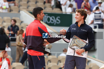 2023-06-11 - Winner Novak Djokovic of Serbia shakes hands with Finalist Casper Ruud of Norway during the trophy ceremony following the Men's Singles Final at the French Open 2023, Roland-Garros 2023, Grand Slam tennis tournament, on June 11, 2023 at Stade Roland-Garros in Paris, France - TENNIS - ROLAND GARROS 2023 - WEEK 2 - INTERNATIONALS - TENNIS