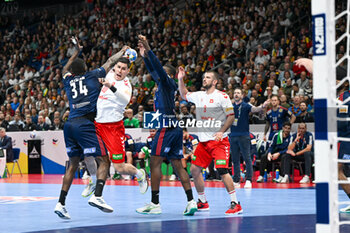 2024-01-14 - Luka Maros (Swiss) in action against Karl Konan (France) during the Men’s EHF Euro 2024 match between Swiss vs. France at the Mercedes-Benz Arena in Berlin, Germany - MEN'S EHF EURO 2024 - SWITZERLAND VS FRANCE - HANDBALL - OTHER SPORTS