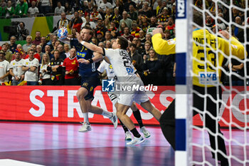 2024-01-28 - Jonathan Carlsbogard (Sweden) ina Renars Uscins (Germany) during 3rd and 4th place final of the Men’s EHF Euro 2024 match between Sweden vs Germany at the Lanxess Arena, Cologne, Germany - MEN'S EHF EURO 2024 - PLACEMENT MATCH 3/4 - SWEDEN VS GERMANY  - HANDBALL - OTHER SPORTS