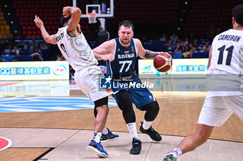 2024-07-04 - 77 Luka Doncic of Slovenia competing with 9 Corey Webster of New Zealand during the FIBA Olympic Qualifying Tournament 2024, match between Slovenia and New Zealand at Peace & Friendship Stadium on July 4, 2024, in Piraeus, Greece. - NEW ZEALAND VS SLOVENIA - FIBA OLYMPIC QUALIFYING TOURNAMENTS - INTERNATIONALS - BASKETBALL