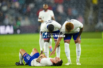 2024-11-18 - United States forward Tim Weah (21) and midfielder Weston McKennie (8) check on a fallen Christian Pulisic (10) - CONCACAF NATIONS LEAGUE - USA VS JAMAICA - OTHER - SOCCER