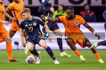 2024-03-22 - Stuart Armstrong of Scotland battles for possession with Lutsharel Geertruida of Netherlands during the International Friendly football match between Netherlands and Scotland on March 22, 2024 at Johan Cruijff ArenA in Amsterdam, Netherlands - FOOTBALL - FRIENDLY GAME - NETHERLANDS V SCOTLAND - FRIENDLY MATCH - SOCCER