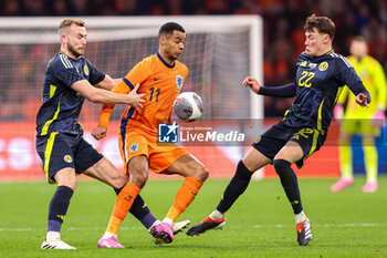 2024-03-22 - Ryan Porteous of Scotland, Cody Gakpo of Netherlands, Nathan Patterson of Scotland during the International Friendly football match between Netherlands and Scotland on March 22, 2024 at Johan Cruijff ArenA in Amsterdam, Netherlands - FOOTBALL - FRIENDLY GAME - NETHERLANDS V SCOTLAND - FRIENDLY MATCH - SOCCER
