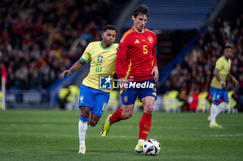 2024-03-26 - Robin Le Normand of Spain (L) in action against Rodrygo Goes of Brazil (R) during the friendly football match among the national teams of Spain and Brazil at Estadio Santiago Bernabeu, Madrid. - SPAIN VS BRAZIL - FRIENDLY MATCH - SOCCER