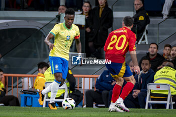 2024-03-26 - Vinicius Junior of Brazil (L) in action with the ball against Daniel Carvajal of Spain (R) during the friendly football match among the national teams of Spain and Brazil at Estadio Santiago Bernabeu, Madrid. - SPAIN VS BRAZIL - FRIENDLY MATCH - SOCCER