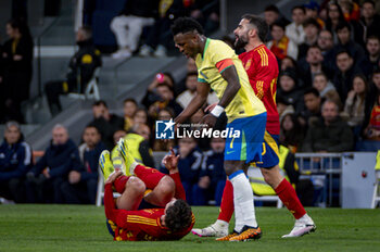 2024-03-26 - Vinicius Junior of Brazil (R) seen helping Robin Le Normand of Spain (L) during the friendly football match among the national teams of Spain and Brazil at Estadio Santiago Bernabeu, Madrid. - SPAIN VS BRAZIL - FRIENDLY MATCH - SOCCER